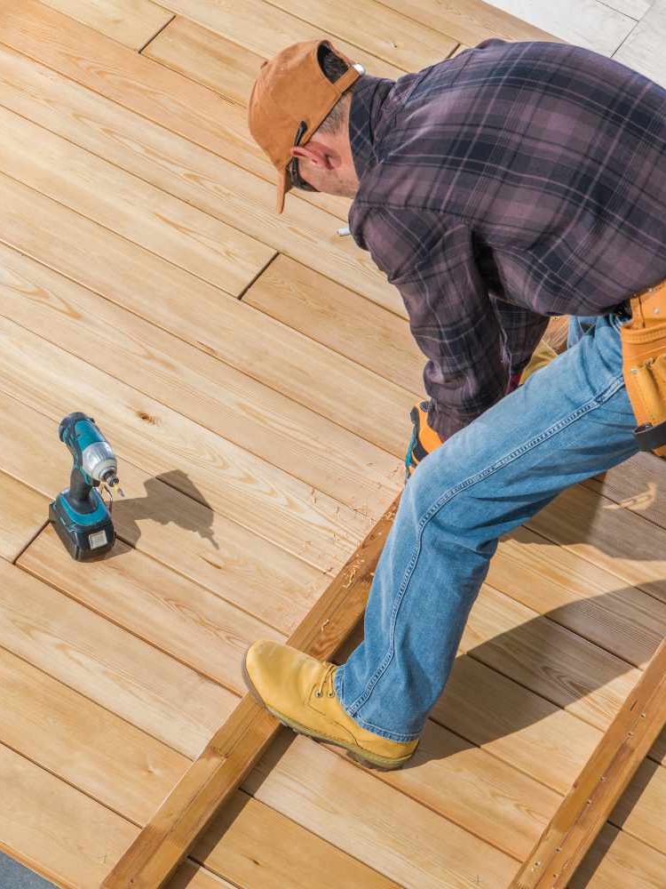 men-building-wooden-deck-on-his-backyard-8SMSLBT.jpg